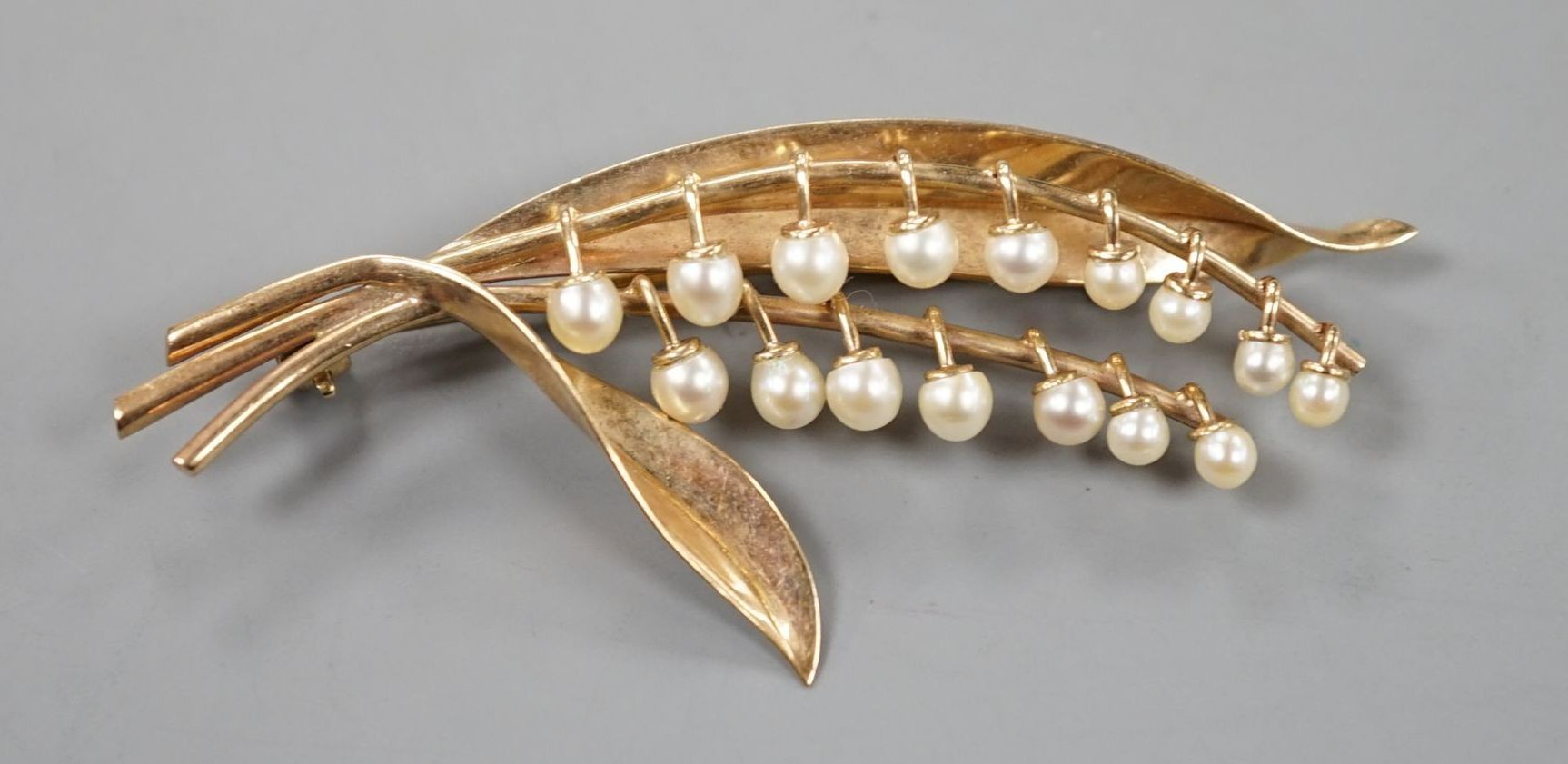 A modern 9ct gold and cultured pearl set spray brooch, 6cm, gross weight 6.7 grams.